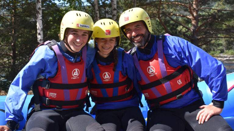 People in life jackets and helmets on a raft