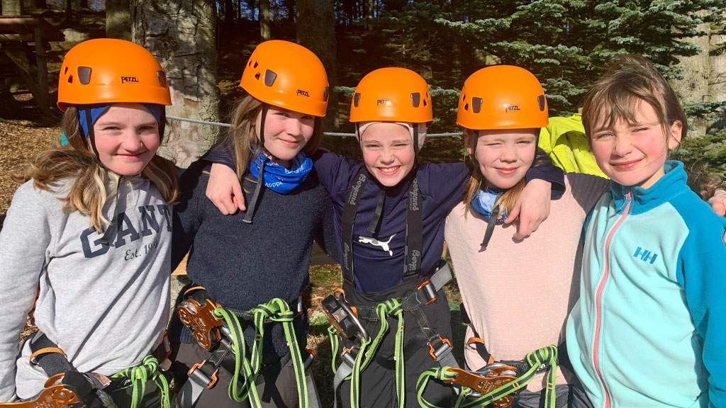 Group of young girls in climbing safety gear