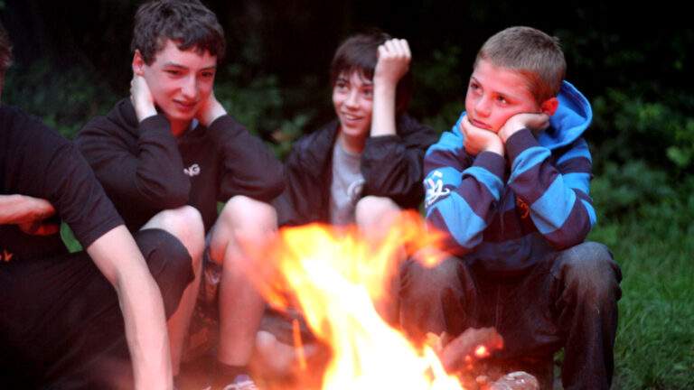 Young boys around a campfire