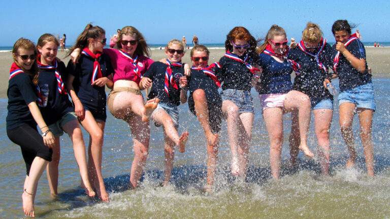Girl guide group on tour in France playing in the sea