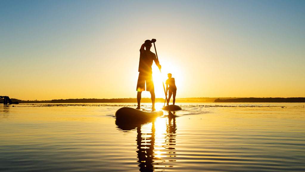 Stand-up paddle boarding at sunrise