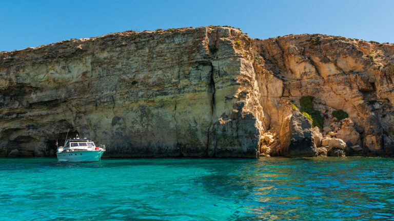 Boat tour to famous Blue Grotto sea caves along Maltese seacoast, Malta