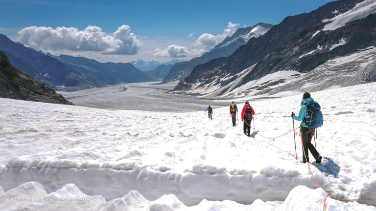 people walking across a glacier