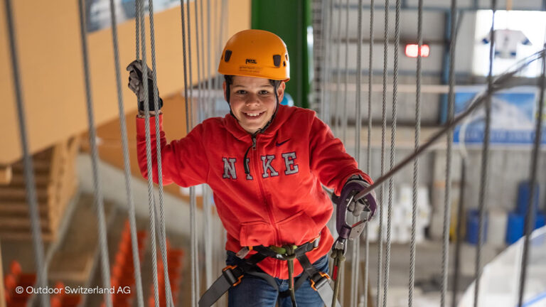 boy in red hoodie on indoor high ropes