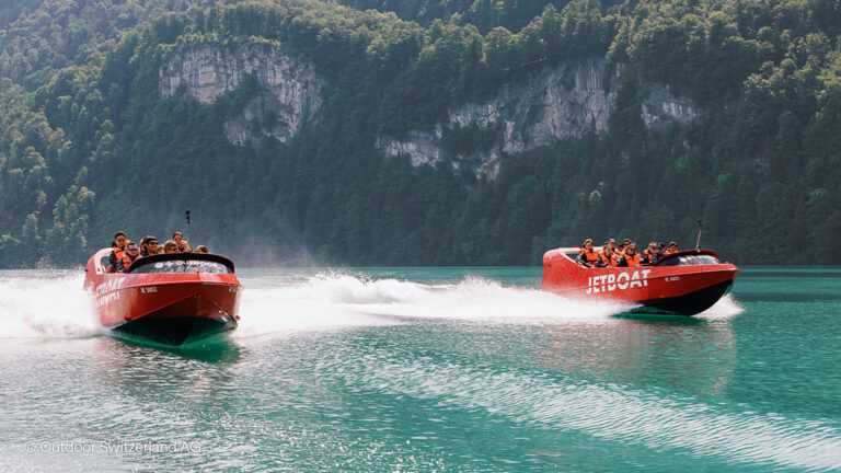 two jetboats speeding across lake