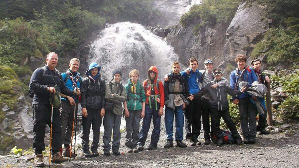 Scouts posing in front of a waterfall in Switzerland