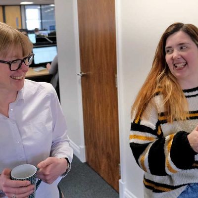 Two people chatting over tea in an office